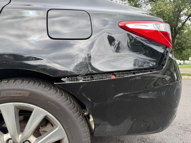 Close-up of the quarter panel dent and horizontal scrapes